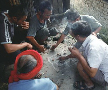 陰雨天,三五瑤民聚在一起玩瑤族傳統(tǒng)“趕豬棋”。